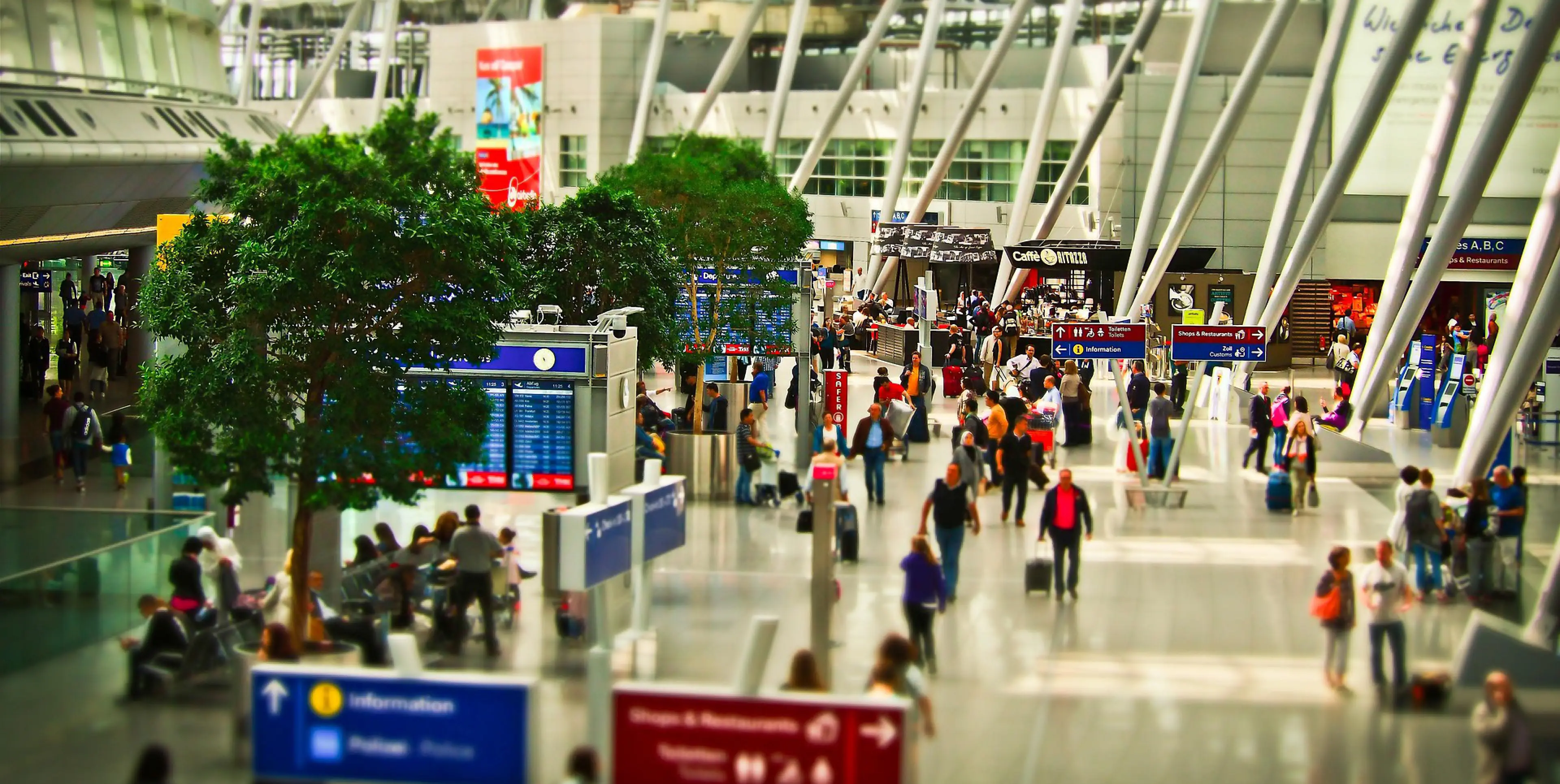 Travellers moving through a busy airport terminal