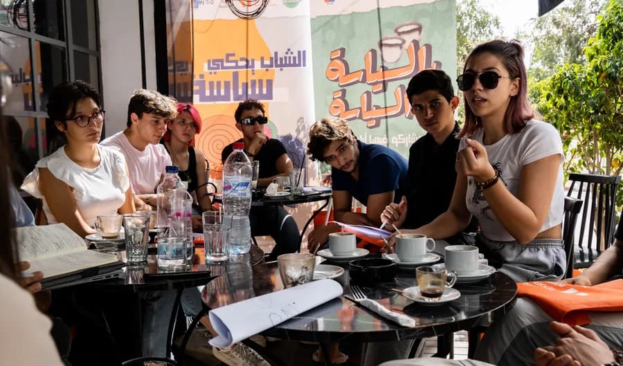 Participants around a table at a DRI workshop, from the Tunis office card