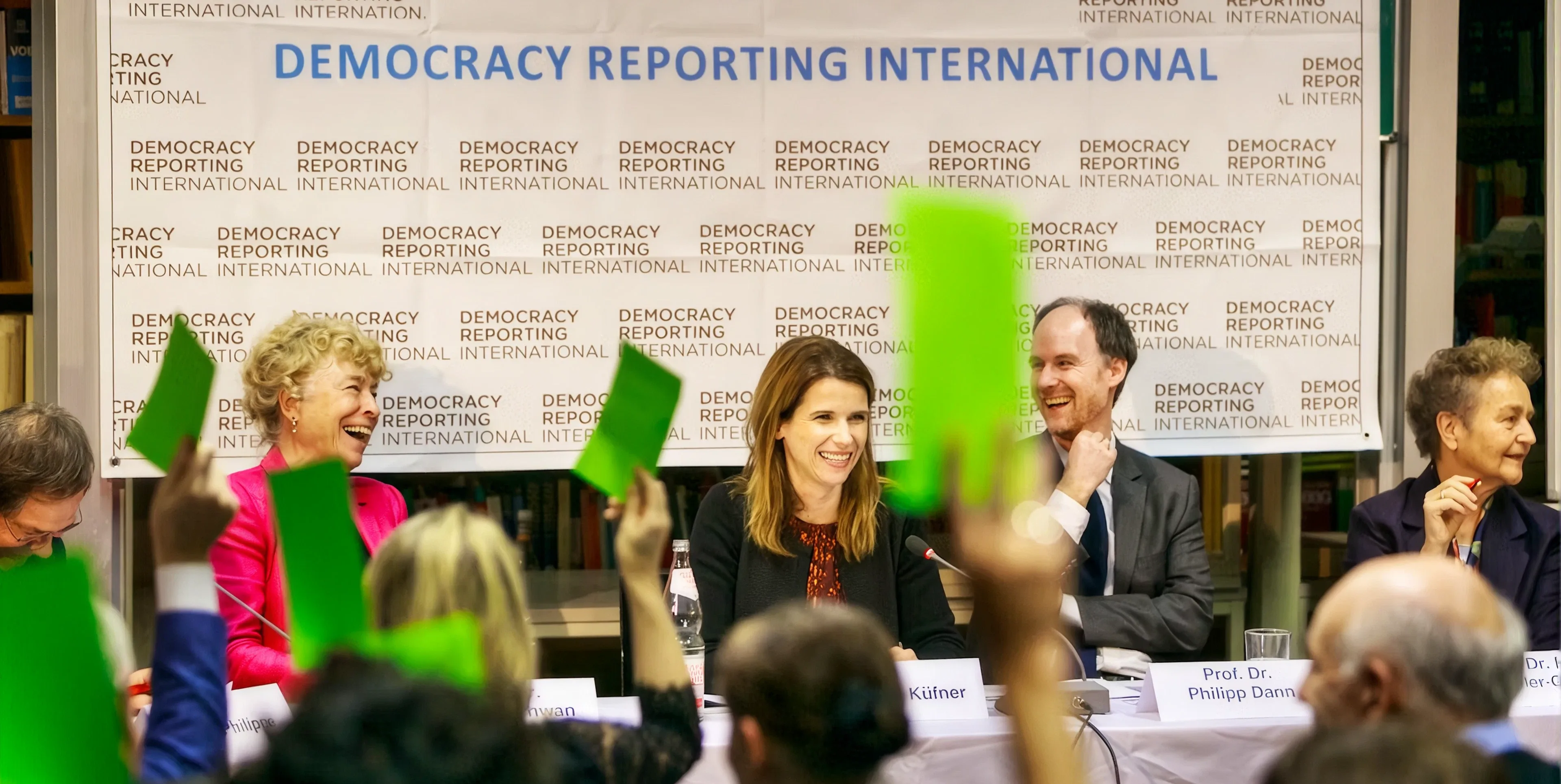 A DRI panel discussion, with the audience holding up green voting cards