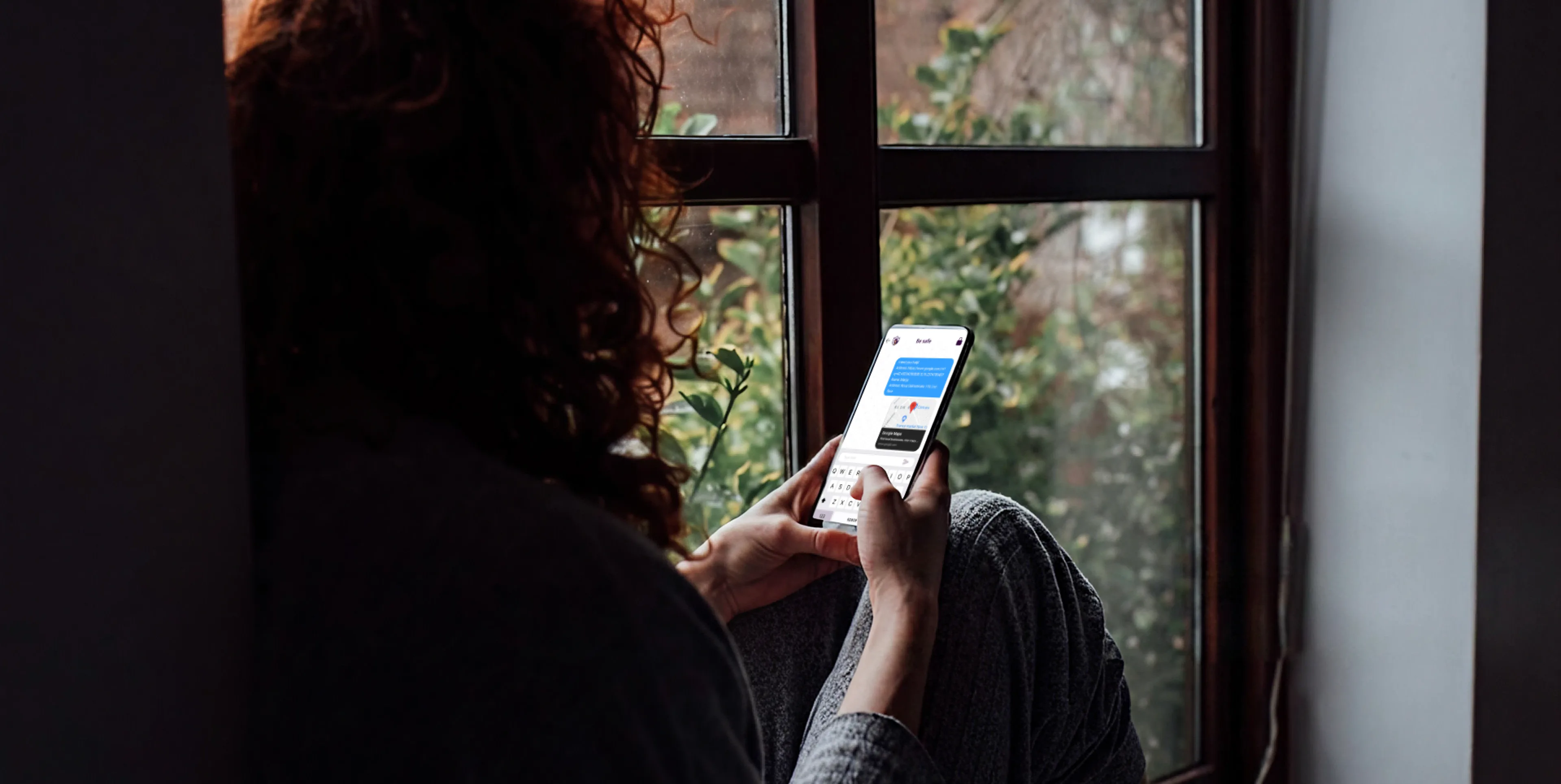 Person holding a phone with the Be Safe app in an ordinary setting