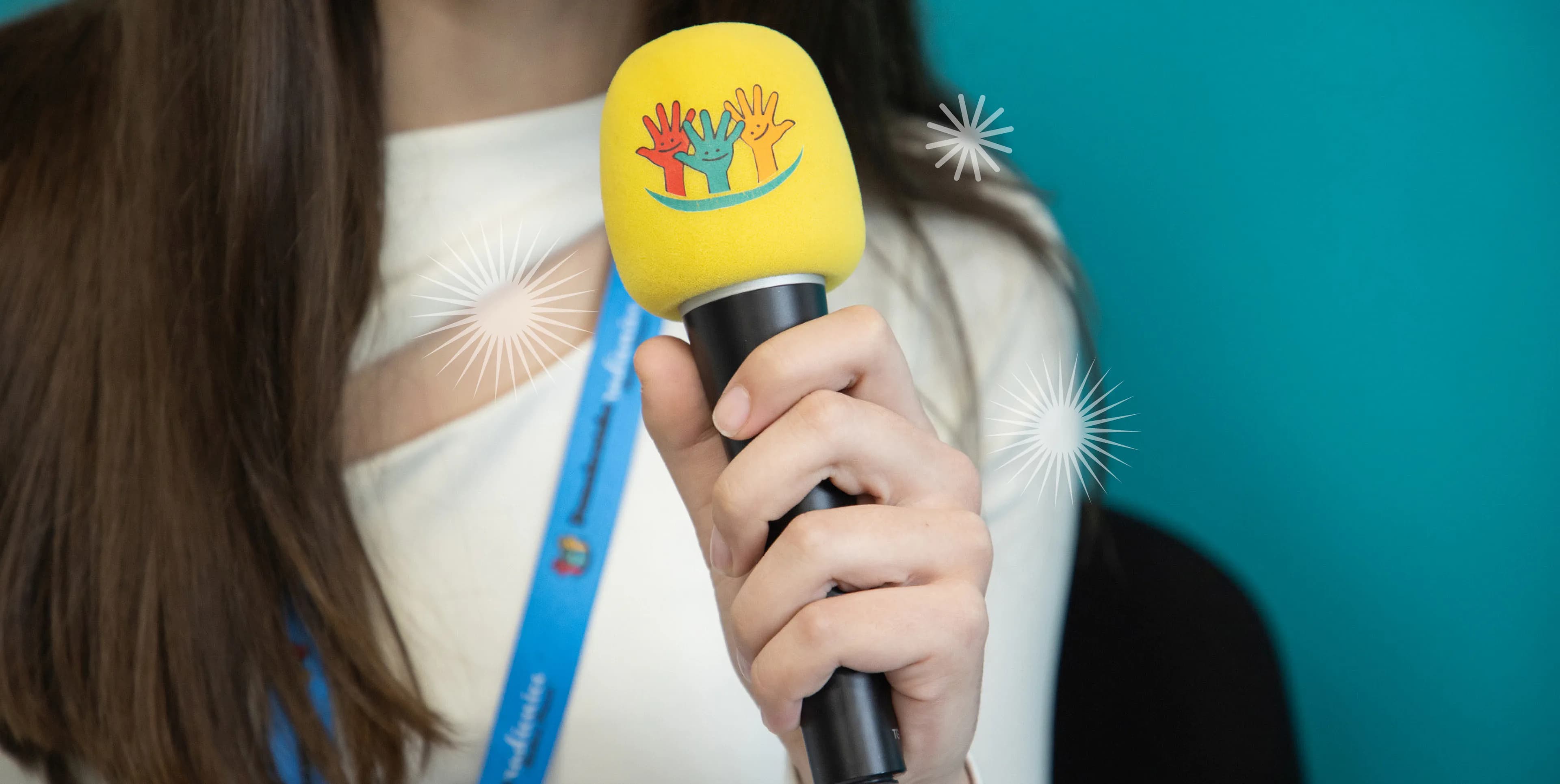 A young participant holding the Education Centre's microphone at a program event